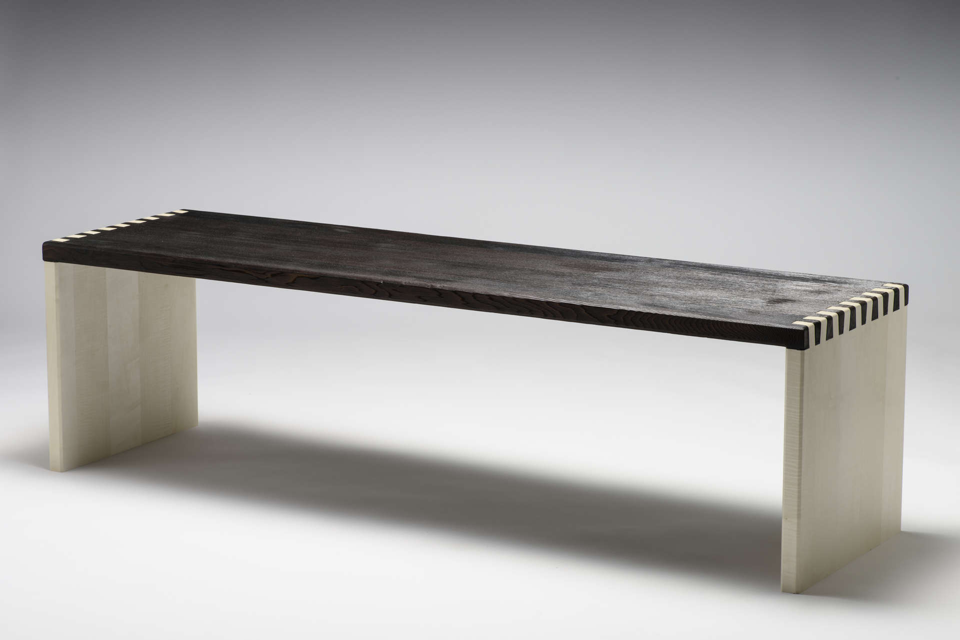 Sitzbank aus Massivholz im japanischen Design. Schwarze Sitzfläche aus geköhltem Zedernholz. Weiße Seitenteile.